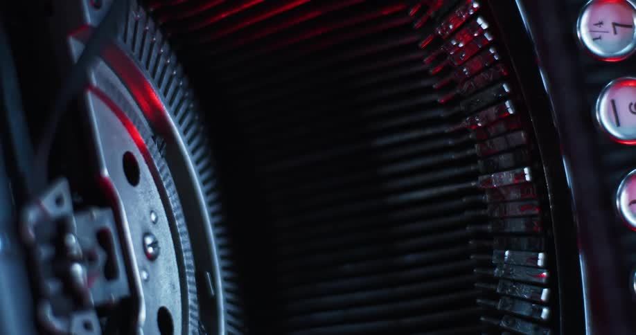 A red light glowing on the key and typebars of a manual typewriter