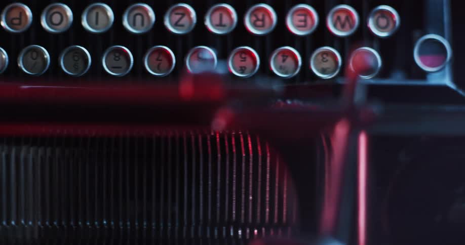 Close up of the red light reflecting on the keys on a vintage typewriter keyboard