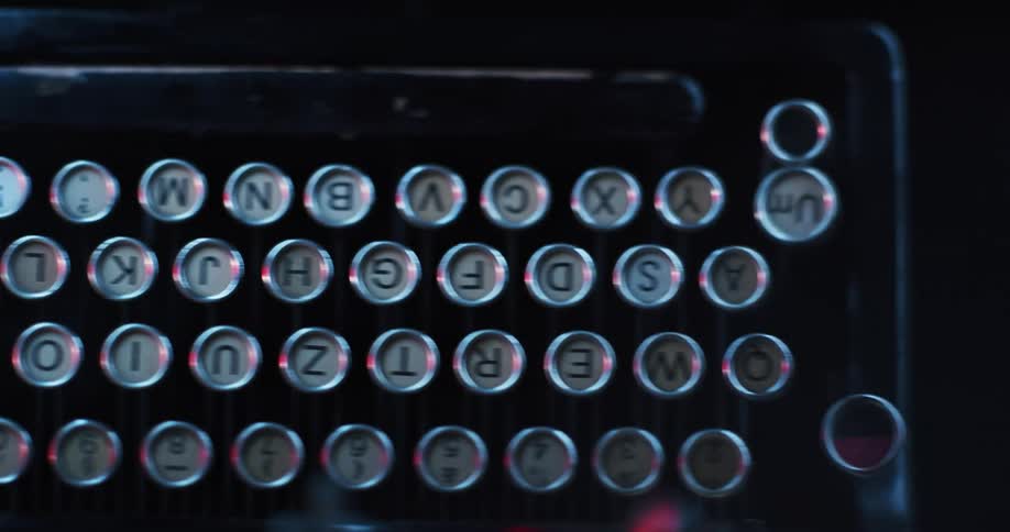 Close up of the red light reflecting on the keys on a vintage typewriter keyboard