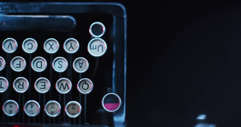 A finger pushes a key on an antique typewriter