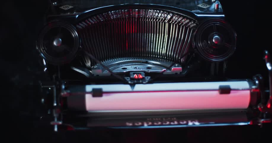 Light shines on the type bars and carriage of an old typewriter as it moves