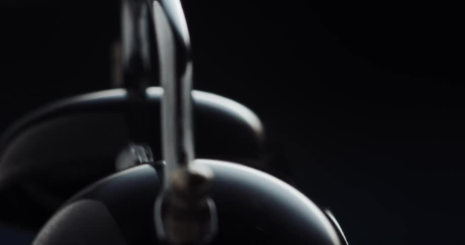 Close up of the hammer of an alarm clock ringing the bells inside a dark room