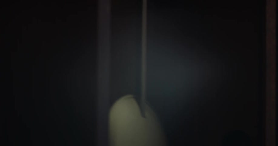 Pendulum of clock swings back and forth in its frame
