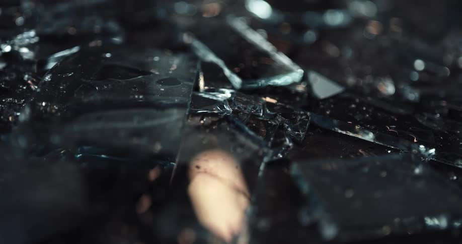 Lights are flickering off of glass shards on the ground