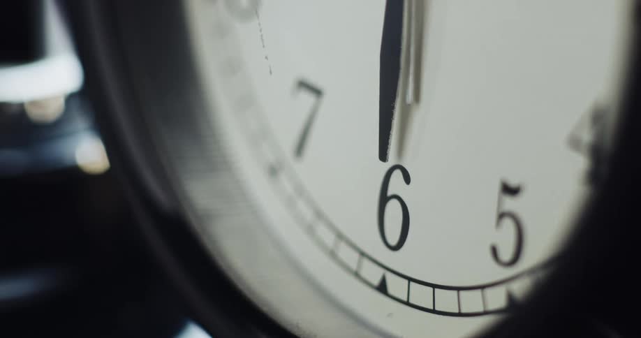 The hands of a clock are pointing down to the six