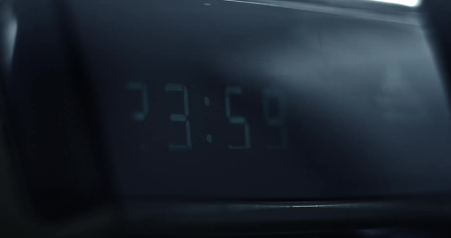 Close up of the screen of a digital alarm clock when the time changes to zero