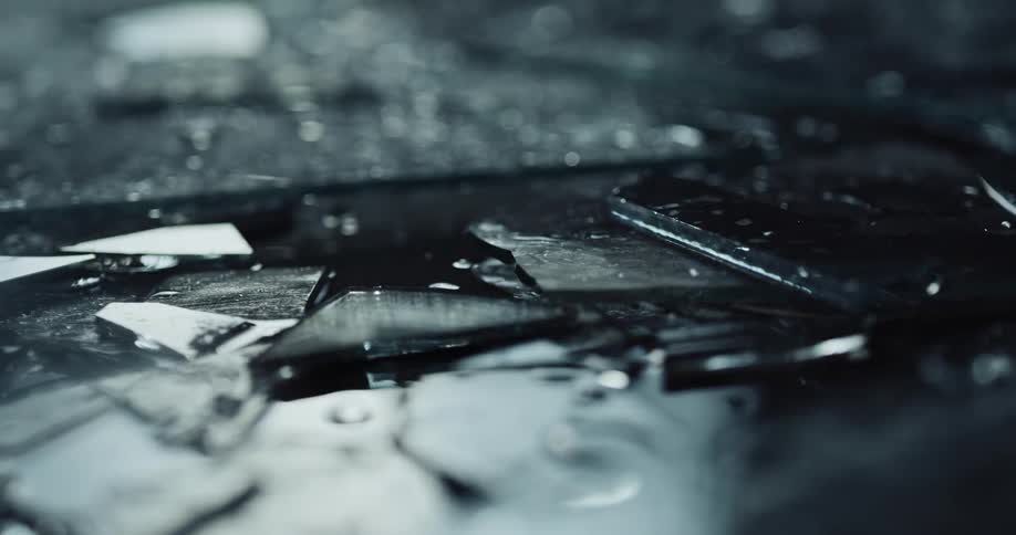 Wet shards of glass are covering the ground