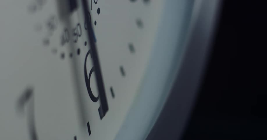 The hands of an analog clock cast a shadow on the clock face