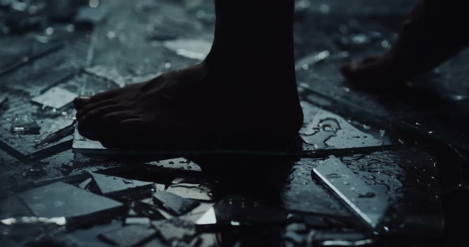 A person is stepping gently and walking barefoot across glass shards