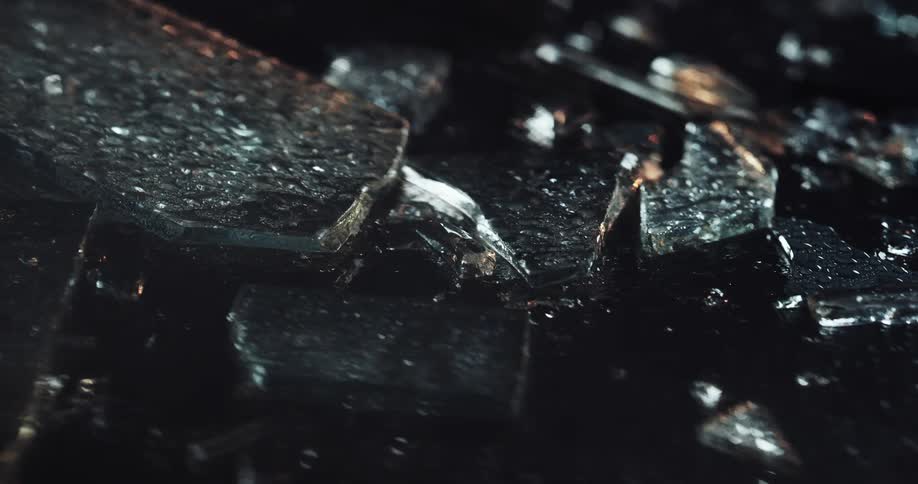 Close up of broken shards of glass while raining at night
