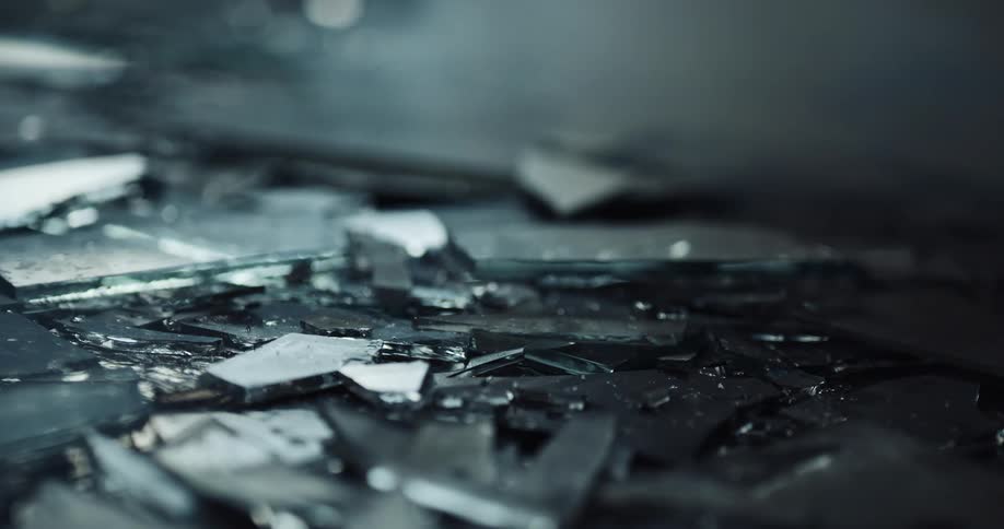 Light shines on shards of broken glass that are on the ground
