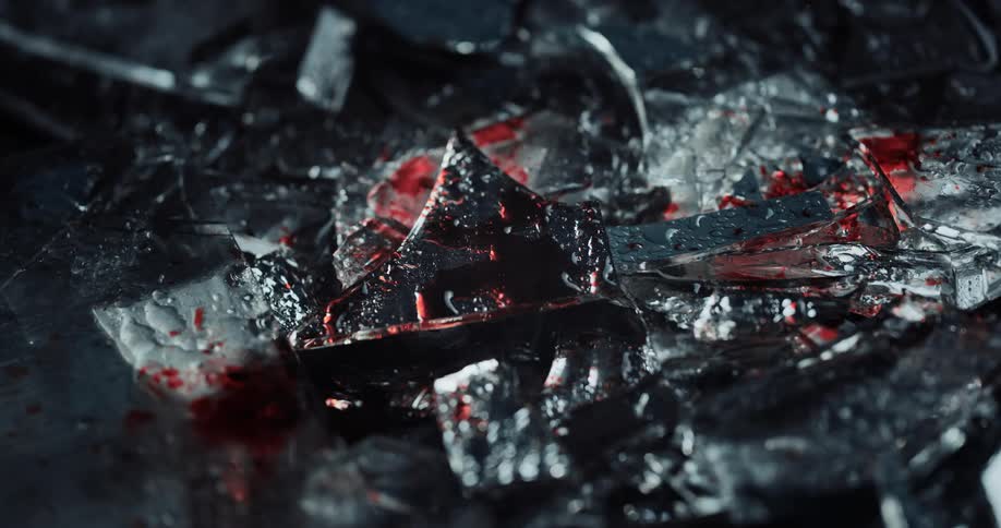 Police lights shine on blood dripping on to shattered glass