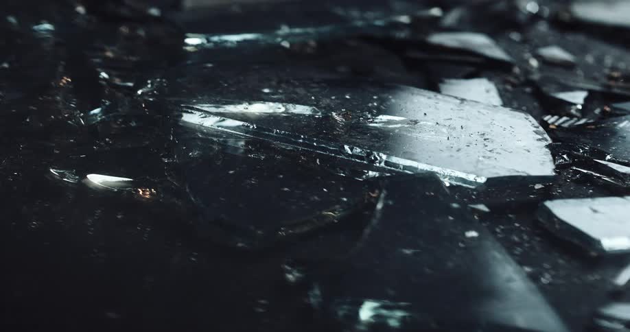 Police flashers reflect on pieces of broken glass on the ground