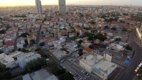 Cars are parked in a lot before this city