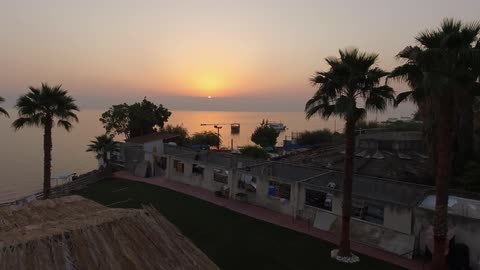 The sun setting on an oceanside village