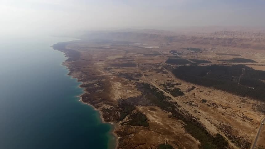 Aerial fly over of a barren coastline during the day