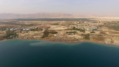 A coastline has hills leading to buildings