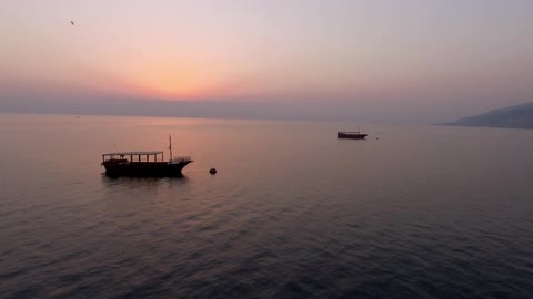 Boats in a body of water at sunset