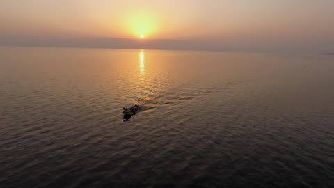 A speedboat travels through the water at sunrise