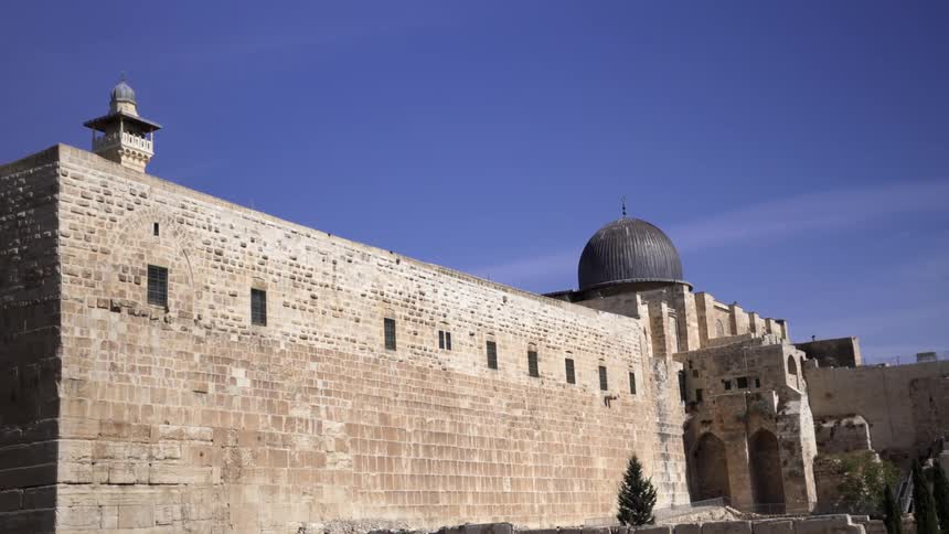 A stone building has a dome at the top