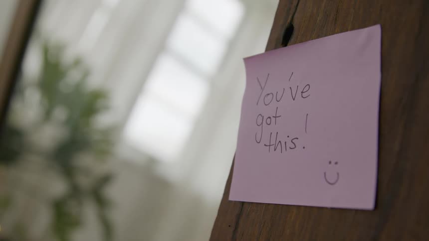 Small note of encouragement pinned to a wall inside a home