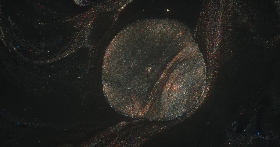 An orb of golden glitter emerges from an organic sparkling pool