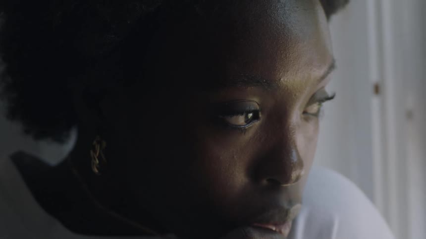 Thoughtful black woman playing with and touching her necklace