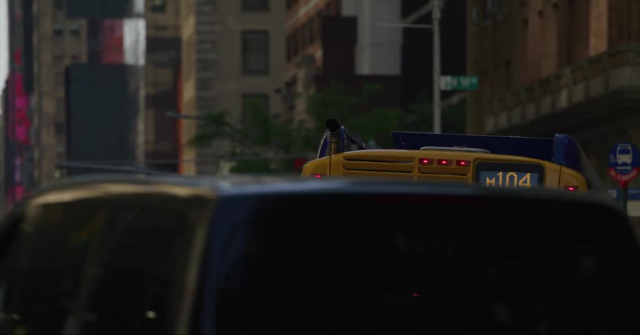 A city bus moves down the street and pulls to the side