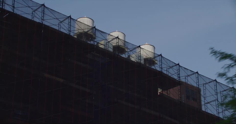 Water tanks on the roof of a building in the city seen from a moving vehicle