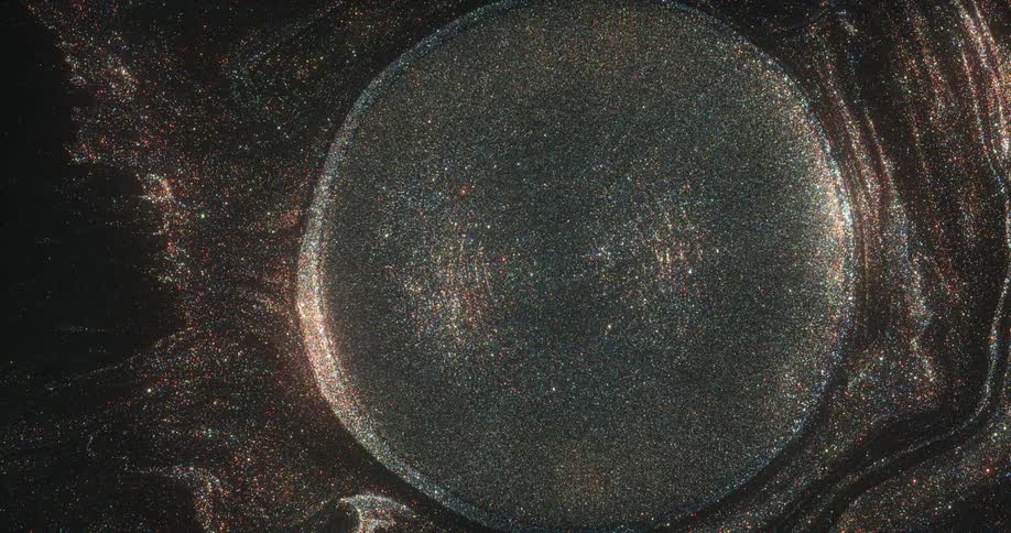 An orb of golden glitter is moving out of a portal in an organic sparkling universe