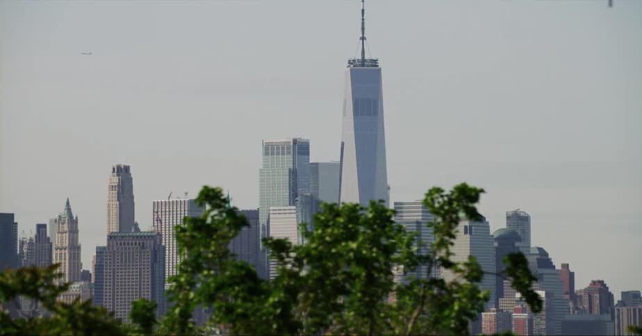 Distant view of skyscraper with spire and high rise buildings in the city