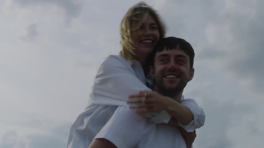 Happy young woman jumping on the back of her boyfriend