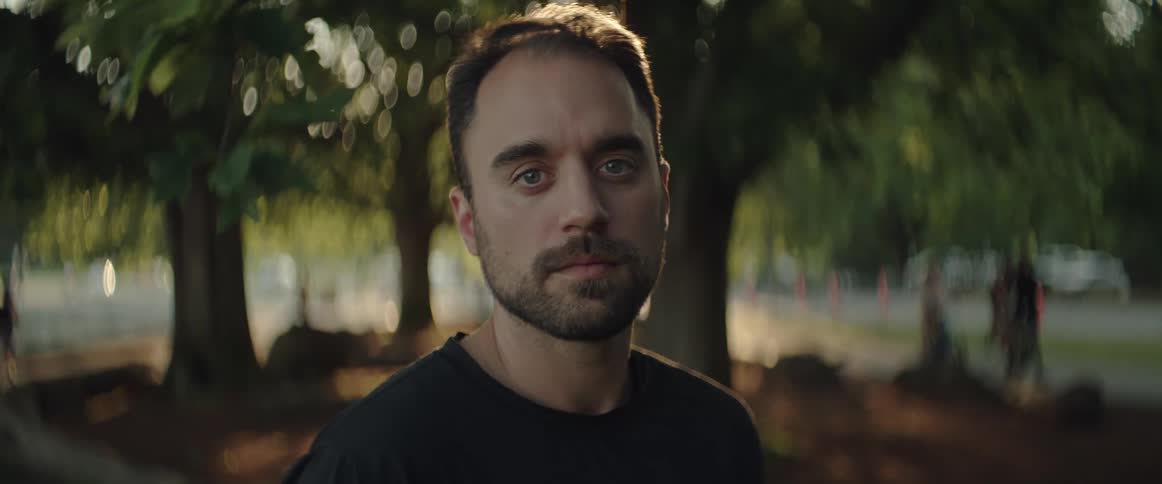 A portrait of a man outside in a park at sunset