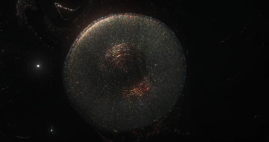An orb of golden glitter emerges from the darkness and sparkles as it grows