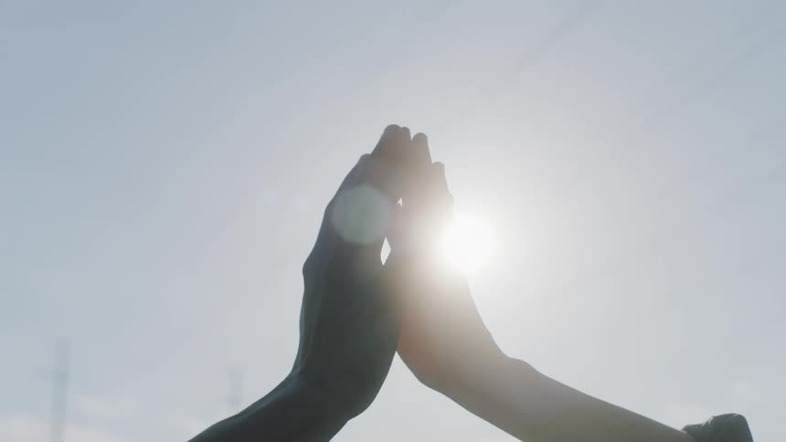 Woman romantically touching and wrapping her hand around the hand of a man