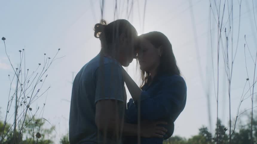 A man and woman hug outside