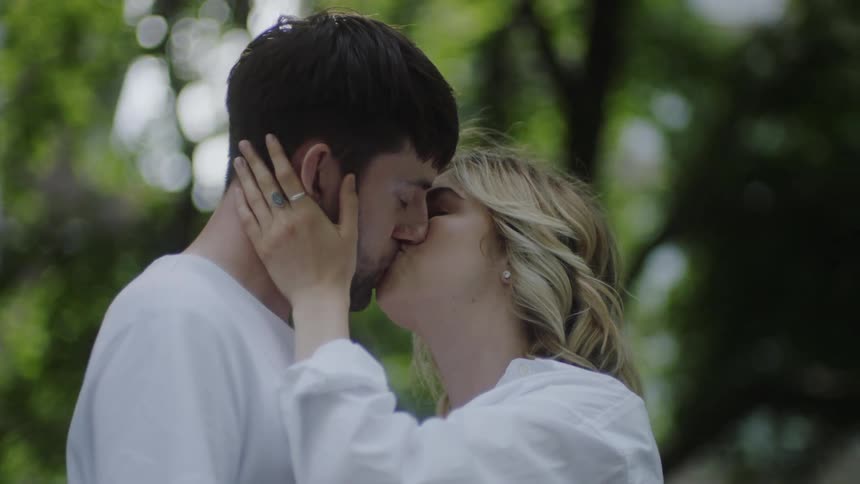 A woman pulls her partner in for a kiss