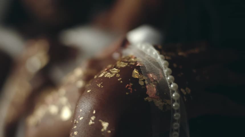 A trio of women stand wearing metallic flakes and a fashion outfit