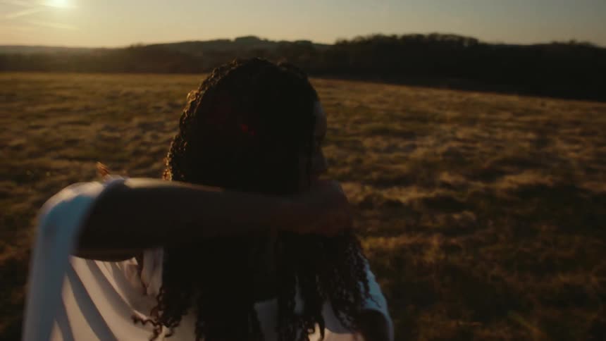 Black woman standing on top of a hill practicing martial arts movements
