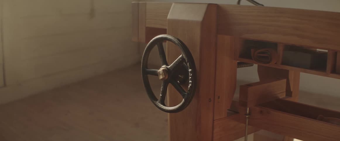 Close up of the metal wheel on a carpentry tool inside a workshop