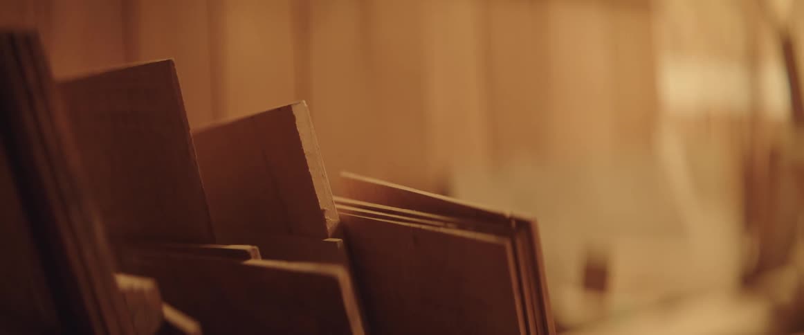 Stacks of lumber are piled in a room