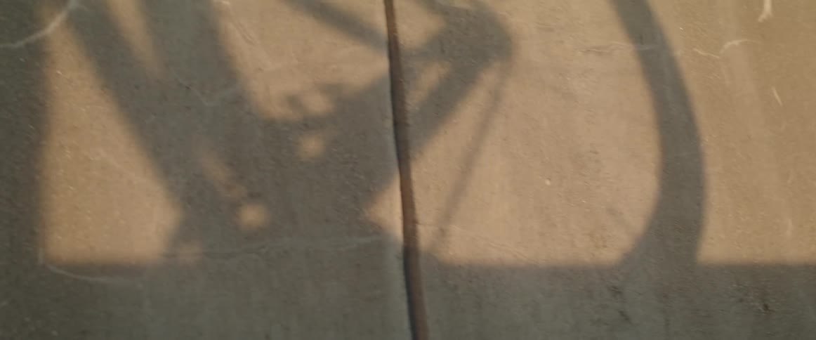 The shadow of a man carrying a bike