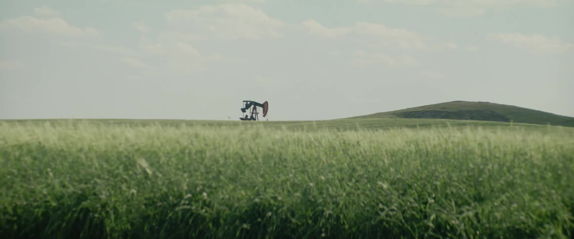A pump jack in a grassy field
