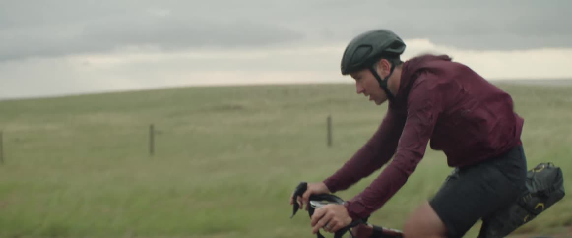 Focused man wearing a bike helmet riding his bike on the road at a windy day