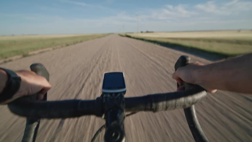 Point of view of a person riding a bicycle on a dirt road in the countryside