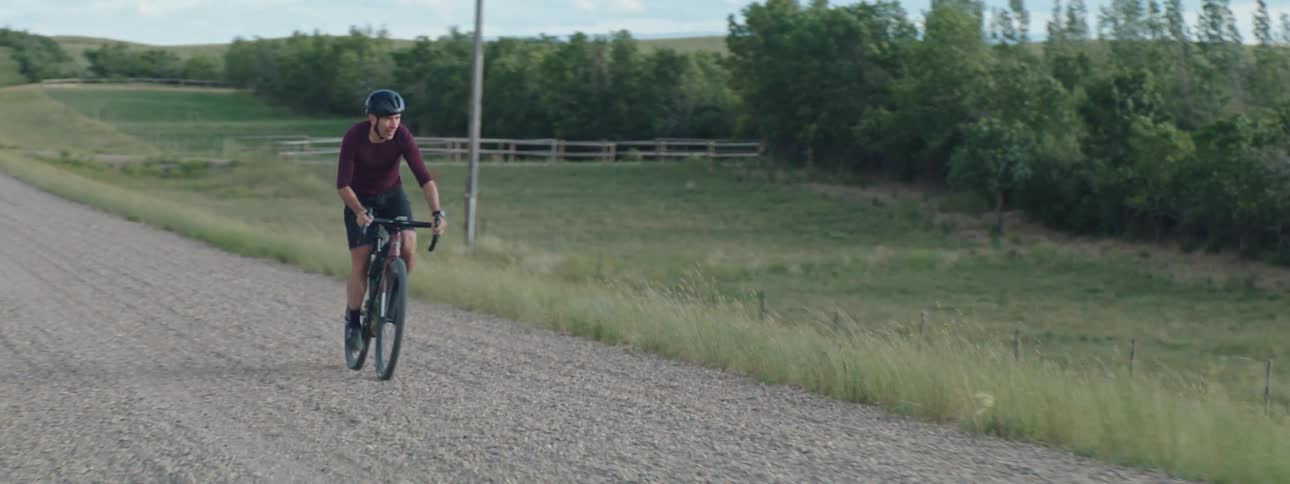 Man wearing a helmet riding a bike in the countryside