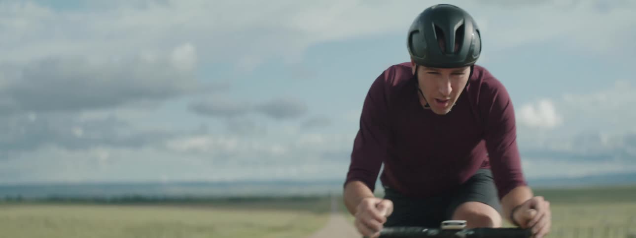 Focused cyclist man riding a bicycle in the middle of an empty road