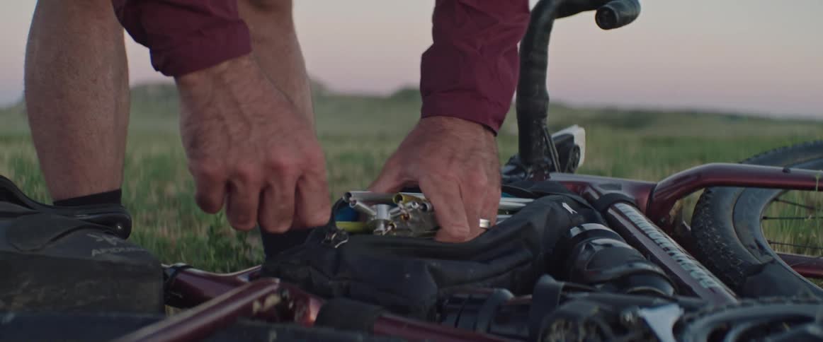 A man grabs items out of a pouch on his bike