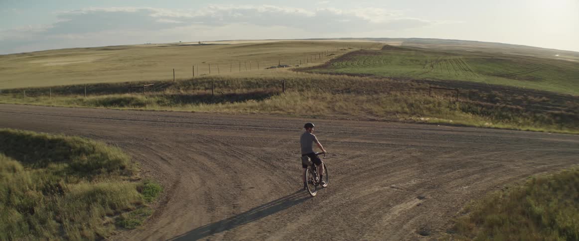 A cyclist comes to a junction of a rural dirt road
