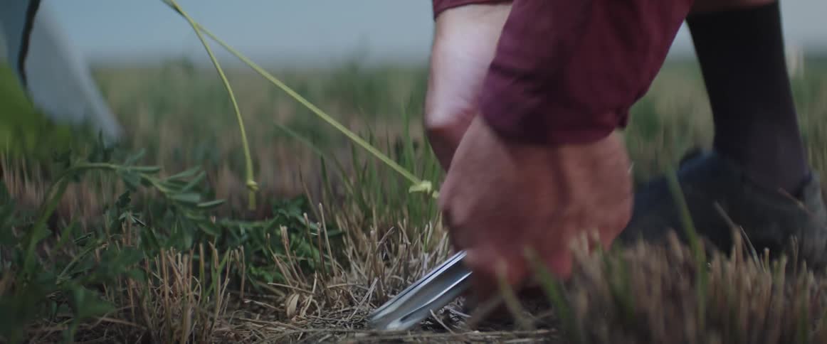 Close up of a man assembling a tent in a field in the countryside